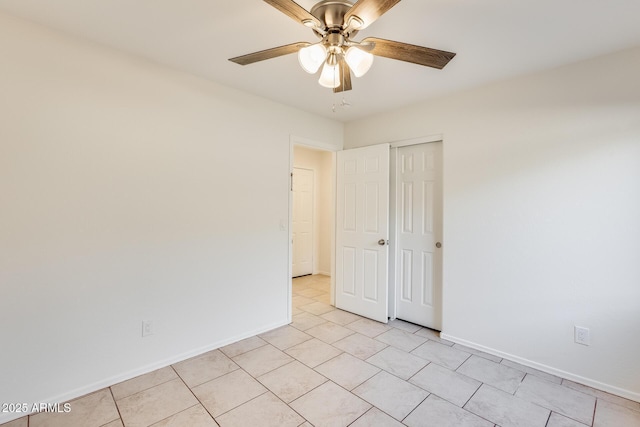 empty room featuring light tile patterned flooring and ceiling fan