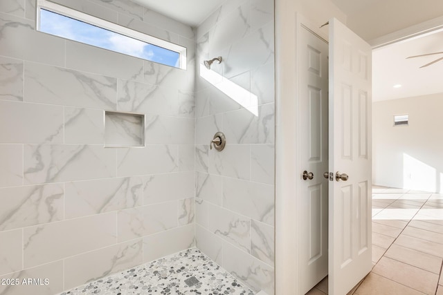 bathroom with tile patterned flooring and a tile shower