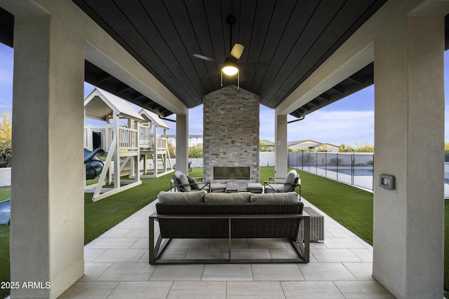 view of patio with an outdoor living space with a fireplace and ceiling fan