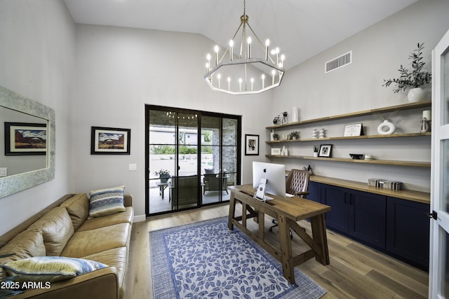 office area with an inviting chandelier, lofted ceiling, and wood-type flooring