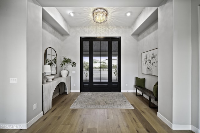 foyer with hardwood / wood-style floors and a notable chandelier