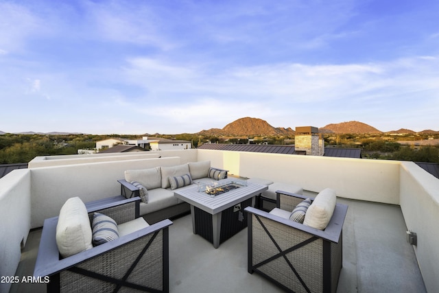 view of patio with a mountain view and an outdoor living space with a fire pit