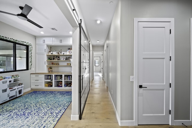 hallway featuring light hardwood / wood-style flooring and a barn door