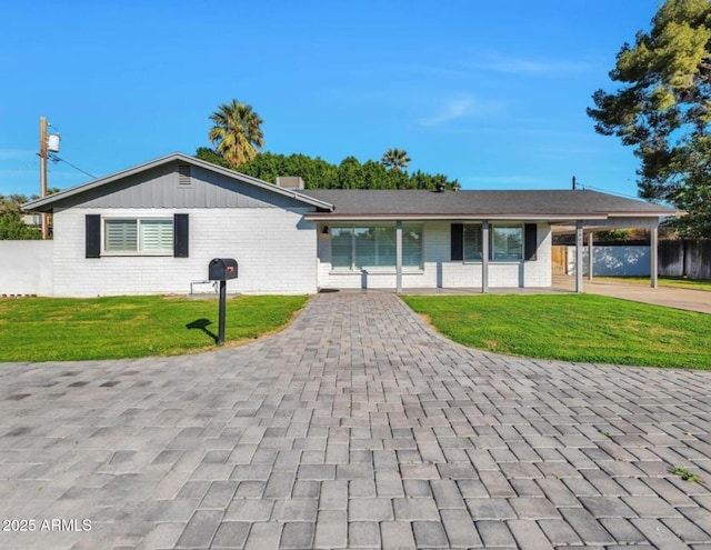6805 N 12th St, Phoenix, AZ 85014 - ranch-style house featuring a front yard, brick siding, board and batten siding, and driveway