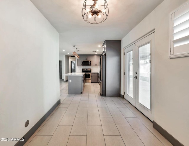 6805 N 12th St, Phoenix, AZ 85014 - kitchen featuring tasteful backsplash, a notable chandelier, light countertops, appliances with stainless steel finishes, and gray cabinetry