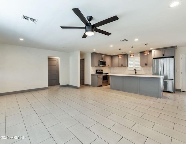 6805 N 12th St, Phoenix, AZ 85014 - kitchen featuring tasteful backsplash, gray cabinets, light countertops, visible vents, and appliances with stainless steel finishes