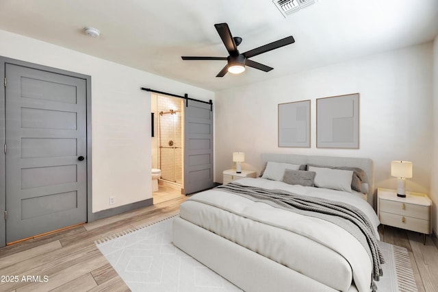 6805 N 12th St, Phoenix, AZ 85014 - bedroom featuring visible vents, baseboards, ensuite bathroom, a barn door, and light wood-style floors