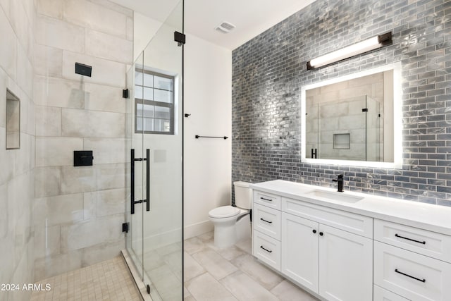 bathroom featuring vanity, tasteful backsplash, toilet, and a shower with shower door