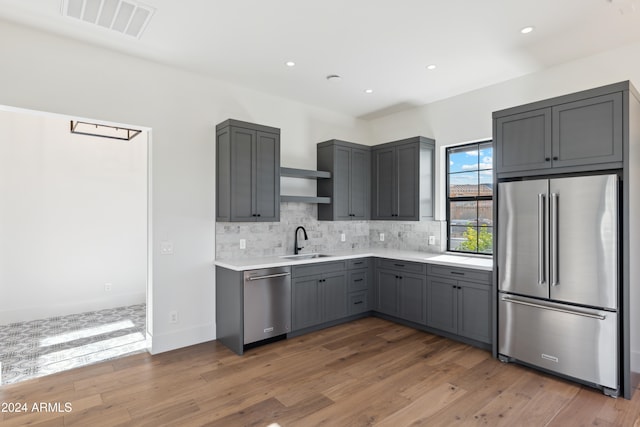 kitchen featuring stainless steel appliances, gray cabinets, dark wood-type flooring, and sink