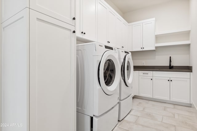 washroom featuring cabinets, washer and clothes dryer, and sink