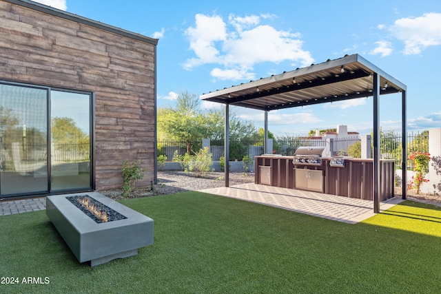 view of yard with a fire pit, a patio, and an outdoor kitchen