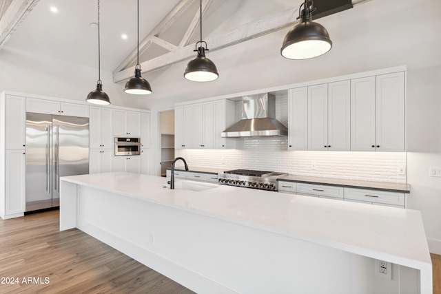 kitchen featuring vaulted ceiling with beams, sink, a spacious island, wall chimney range hood, and stainless steel appliances