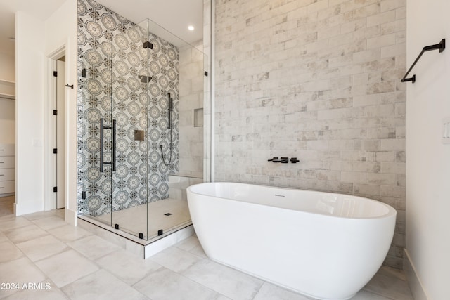 bathroom featuring tile patterned floors, independent shower and bath, and tile walls