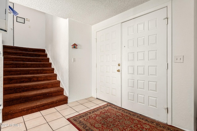 tiled entrance foyer featuring a textured ceiling