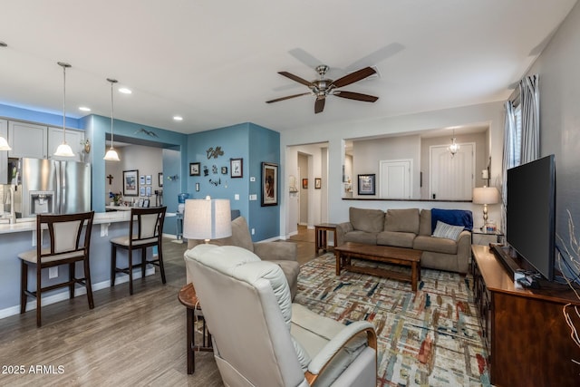 living area featuring recessed lighting, baseboards, a ceiling fan, and wood finished floors