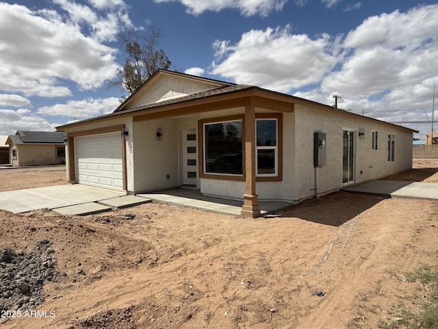 ranch-style house with an attached garage, stucco siding, and concrete driveway