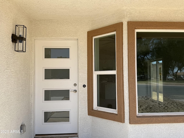 doorway to property featuring stucco siding