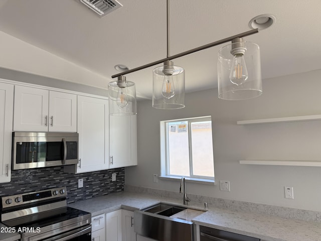 kitchen with white cabinets, open shelves, appliances with stainless steel finishes, a sink, and visible vents