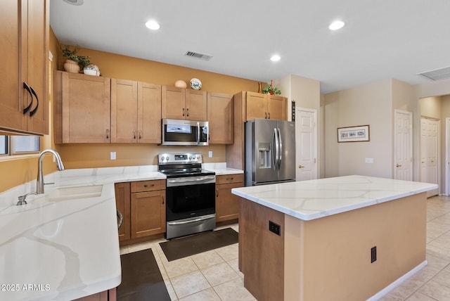 20394 N Coronado Way, Surprise, AZ 85374 - kitchen featuring appliances with stainless steel finishes, a kitchen island, light tile patterned flooring, light stone counters, and recessed lighting