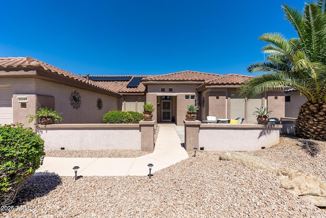 20394 N Coronado Way, Surprise, AZ 85374 - mediterranean / spanish-style home featuring a fenced front yard, roof mounted solar panels, a tile roof, and stucco siding