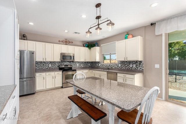 kitchen with decorative backsplash, decorative light fixtures, appliances with stainless steel finishes, and sink