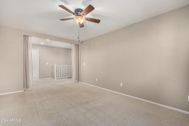 carpeted spare room featuring ceiling fan