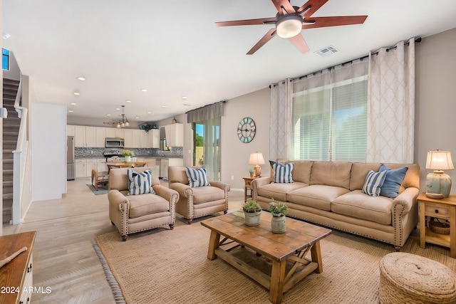 living room featuring light hardwood / wood-style floors and ceiling fan