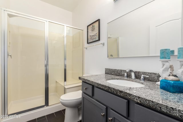 bathroom with a stall shower, vanity, and toilet