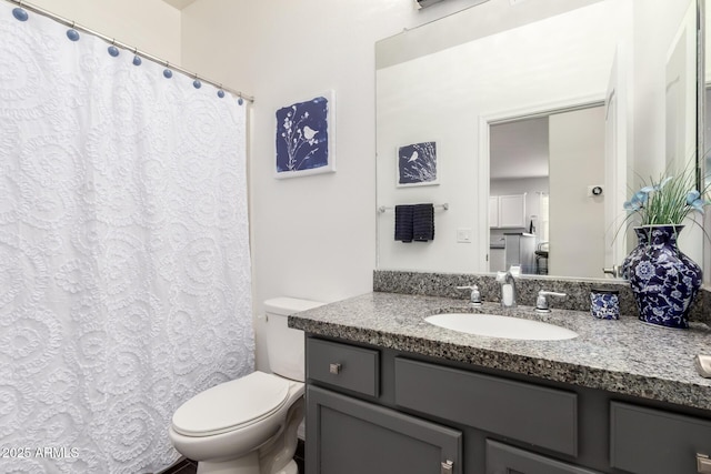 bathroom featuring toilet, curtained shower, and vanity