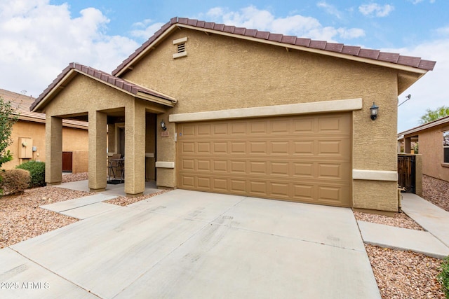 view of front of home with a garage, concrete driveway, a tiled roof, and stucco siding