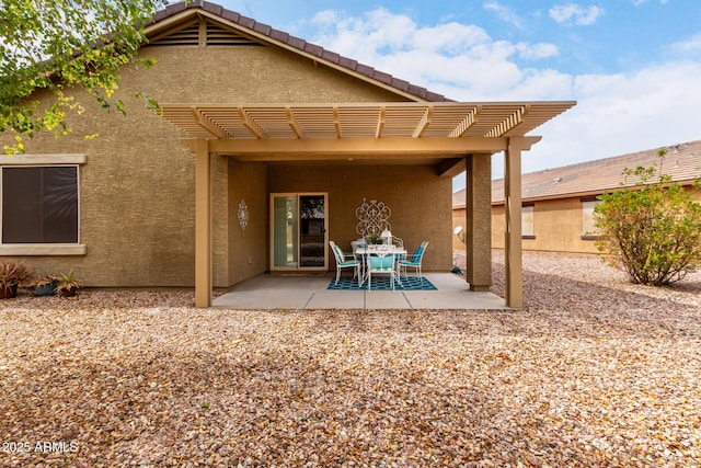 back of house with stucco siding, a patio area, and a pergola