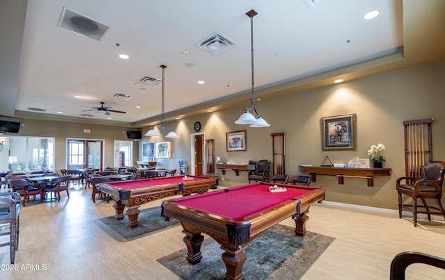 rec room with visible vents, a raised ceiling, and wood finished floors