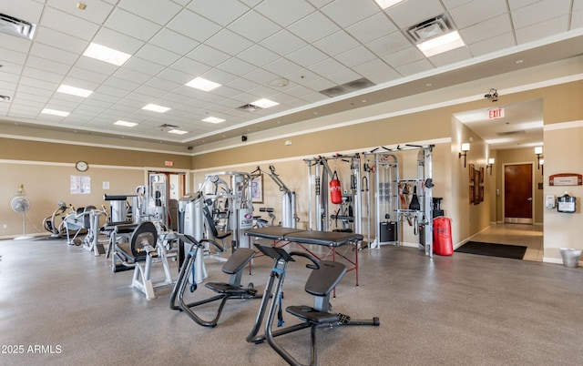 exercise room with a drop ceiling, visible vents, and baseboards