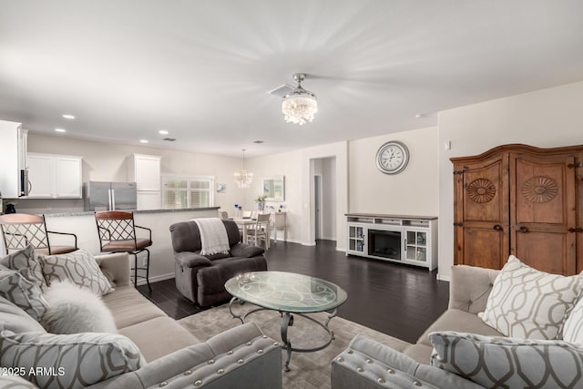 living area with a fireplace, a chandelier, wood finished floors, and recessed lighting