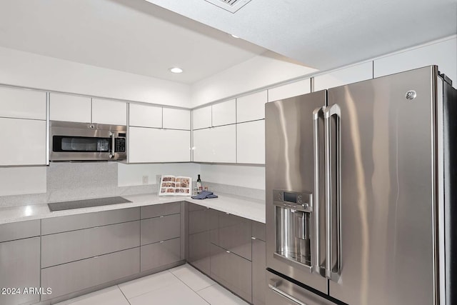 kitchen featuring white cabinets, light tile patterned floors, and appliances with stainless steel finishes