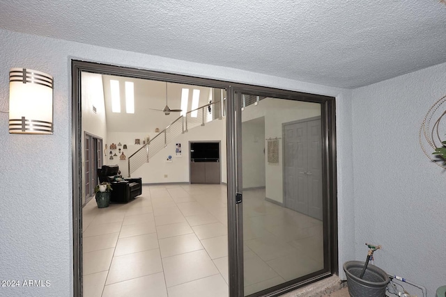 hallway featuring light tile patterned floors and a textured ceiling