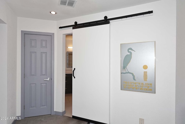 bedroom featuring carpet and a barn door