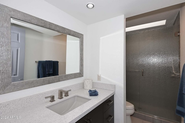 bathroom with vanity, a shower with shower door, and toilet