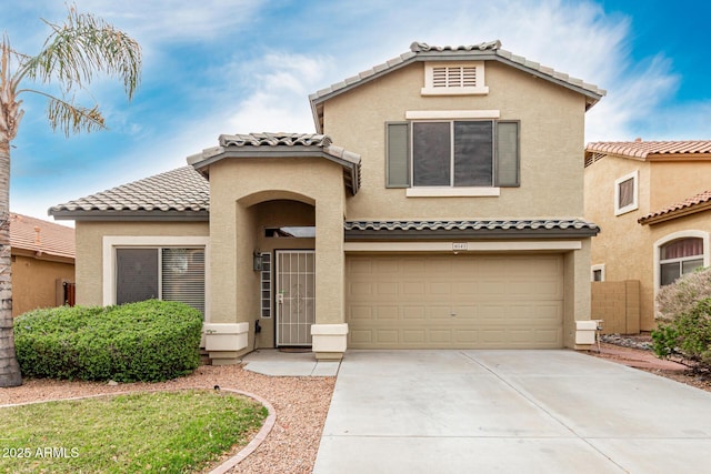 mediterranean / spanish-style home featuring stucco siding, an attached garage, a tile roof, and concrete driveway