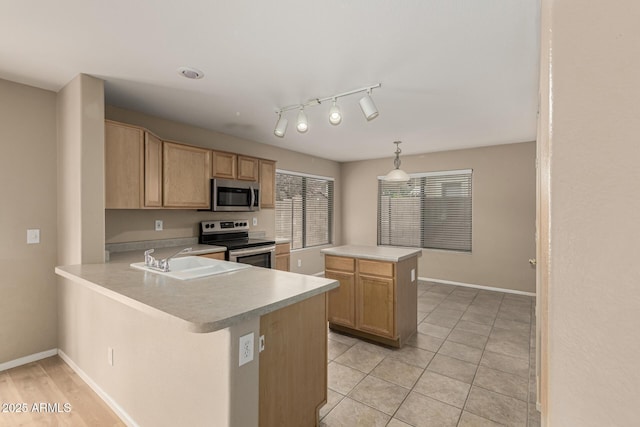 kitchen with light brown cabinetry, a sink, stainless steel appliances, light tile patterned flooring, and light countertops