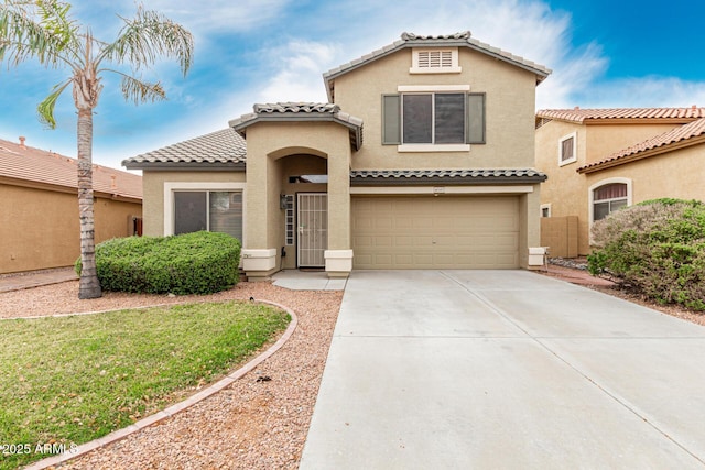 mediterranean / spanish-style home with stucco siding, driveway, a tile roof, and an attached garage