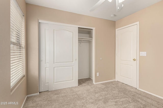 unfurnished bedroom featuring a closet, baseboards, carpet, and ceiling fan