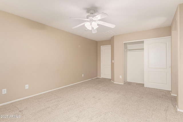 unfurnished bedroom featuring baseboards, visible vents, ceiling fan, a closet, and carpet flooring