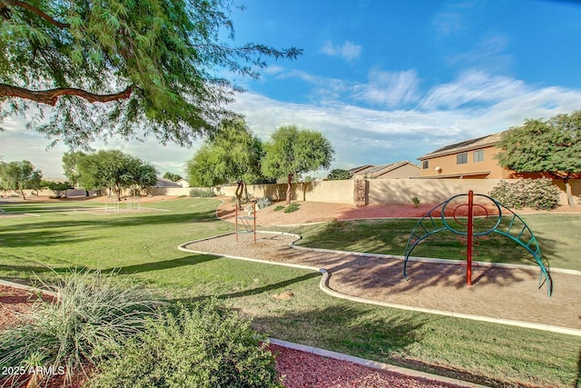 view of home's community featuring playground community, a yard, and fence