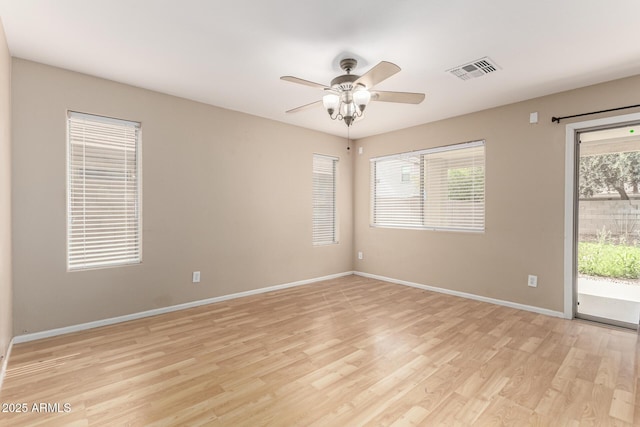 empty room with ceiling fan, visible vents, baseboards, and light wood-style flooring