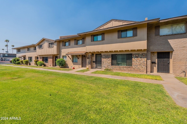 townhome / multi-family property featuring a front yard