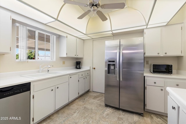 kitchen with a toaster, stainless steel appliances, a sink, a ceiling fan, and light countertops