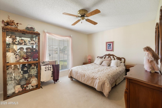 bedroom featuring light colored carpet, ceiling fan, and a textured ceiling