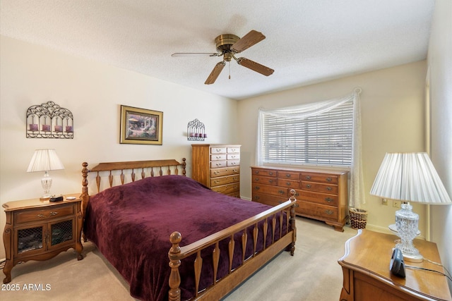 bedroom featuring light carpet, a ceiling fan, and a textured ceiling