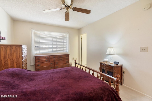 bedroom with a textured ceiling, carpet flooring, a ceiling fan, and baseboards